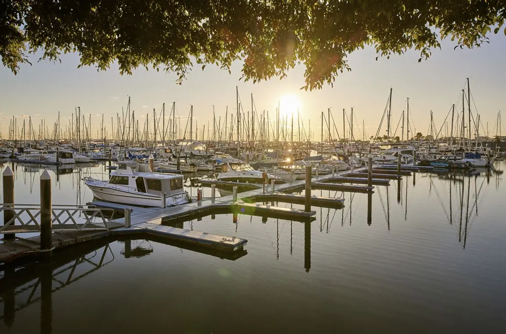 Marina full of moored boats and sailboats at sunset