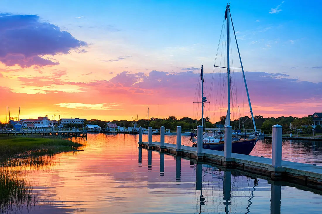 Sailboat moored at a quiet dock at sunset