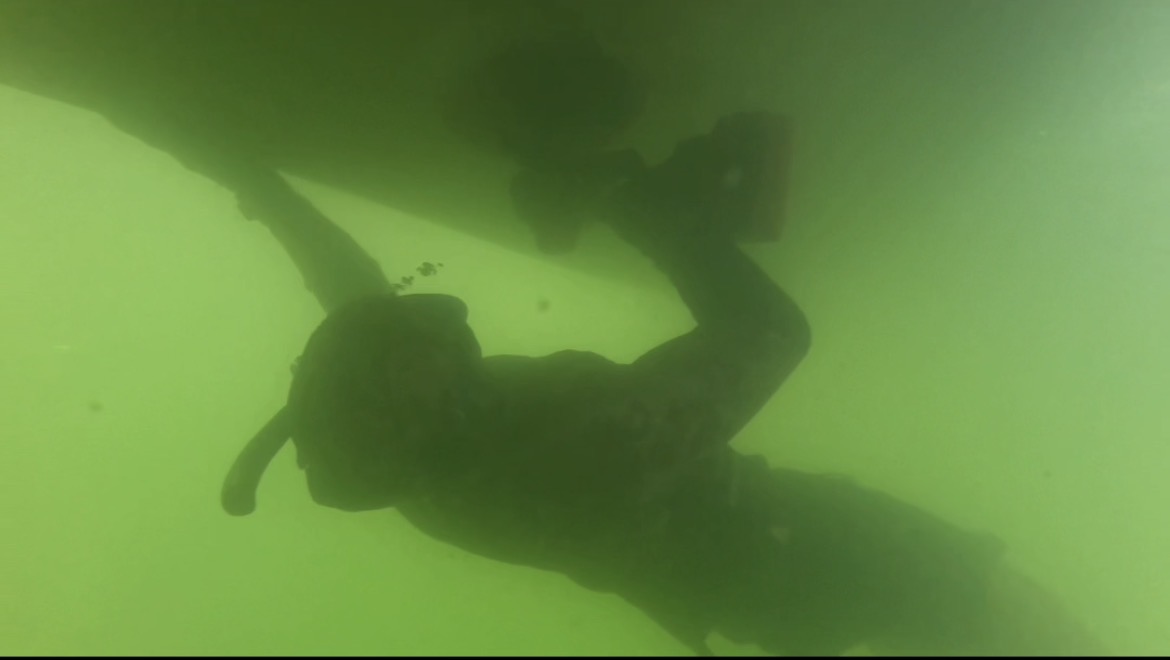 Neptune diver working along the underside of a vessel hull